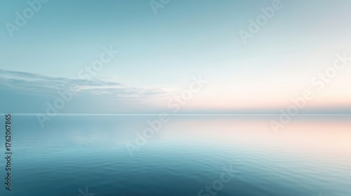 Calm water reflects pastel skies at dawn over tranquil sea