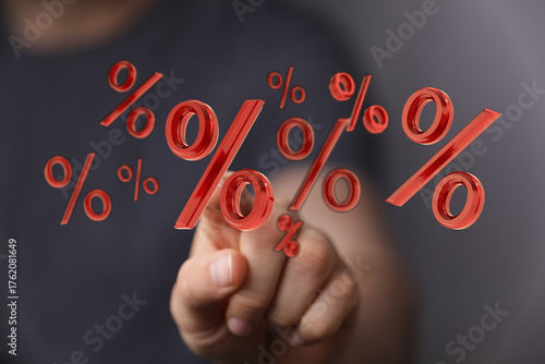 Concept image featuring floating red percentage symbols near a person's hand, representing financial concepts, deals, and interest.