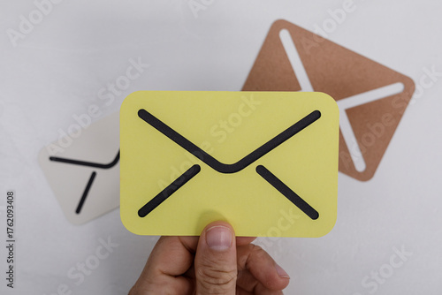 A hand holding a yellow env...