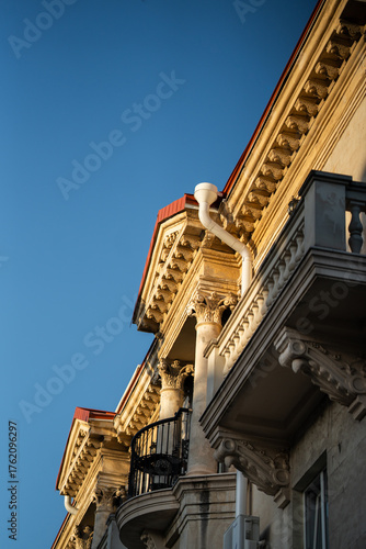 A 19th-century building against a blue sky. A balcony with columns.