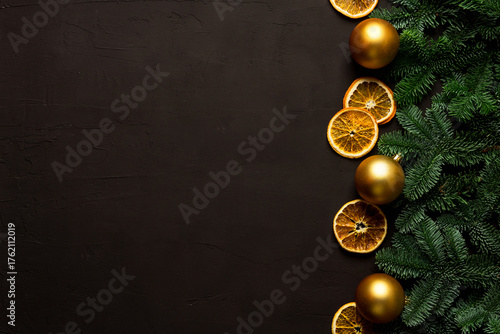 Black background with magnificent fir branches and golden christmas balls. Shot from above. Christmas mood background.