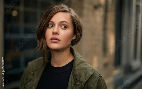Wallpaper Mural Outdoor Portrait of a Pensive Young Woman with Short Hair Looking Away on a Blurry Urban Street Torontodigital.ca