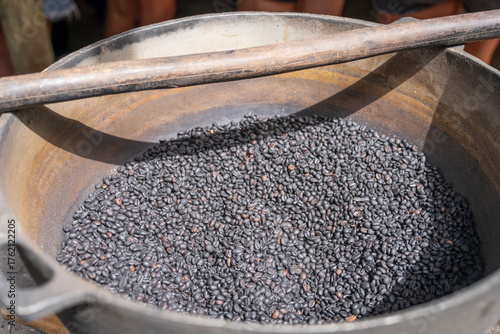 A bowl of dark roasted coffee beans outdoor at sunny day, Suitable for marketing or business purposes.close-up top view