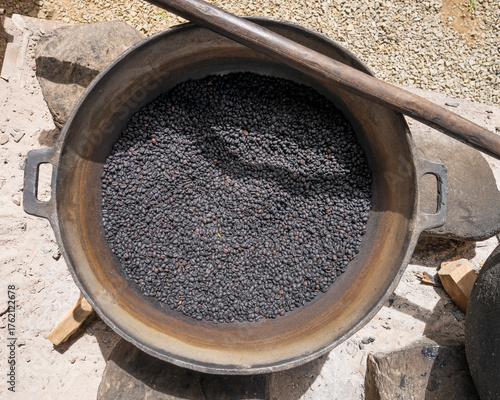 A bowl of dark roasted coffee beans outdoor at sunny day, Suitable for marketing or business purposes.close-up top view