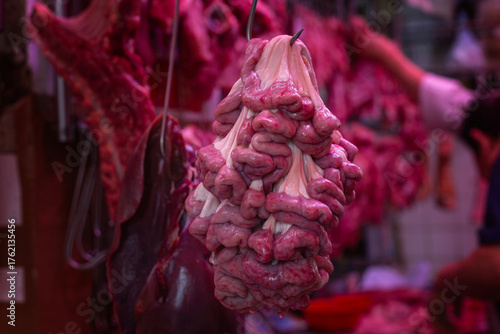 Fresh raw brains hang on a metal hook at a meat market in Hong Kong. Delicacies and offal. Close-up.