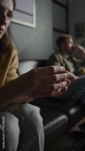 Vertical closeup shot of young woman speaking emotionally in therapy session for couples with focus on hands gesturing and covering face