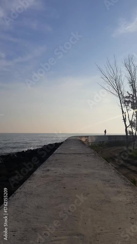 People doing light exercise on the beach barrier in the morning can be seen from a distance