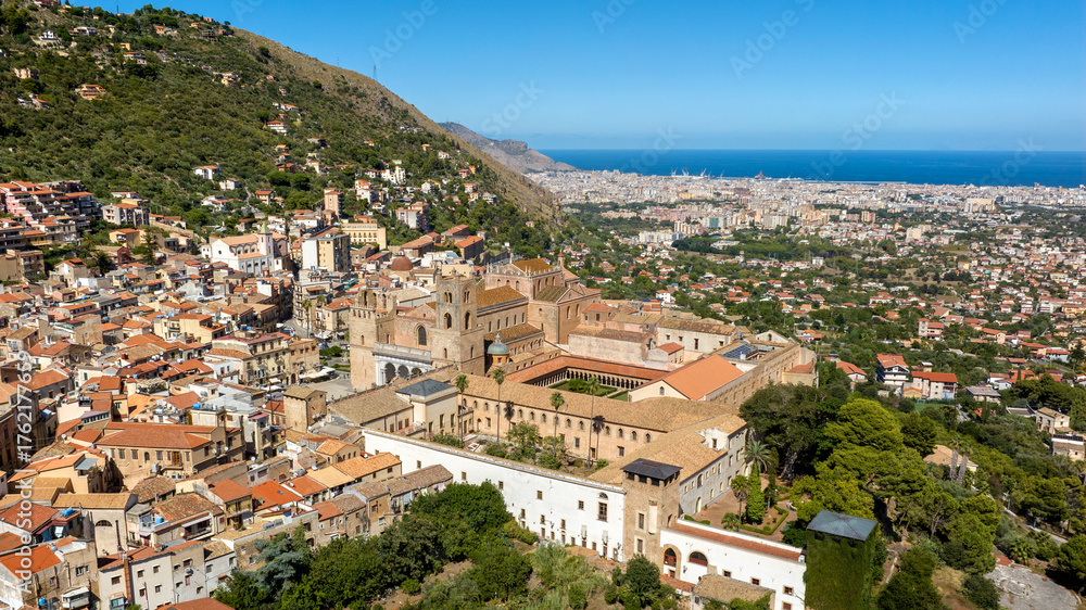 Fototapeta premium Aerial view of Monreale Cathedral. It's a Catholic church, a masterpiece of Norman architecture, located in the historic center of the town in Sicily, Italy. The Mediterranean Sea is in the background
