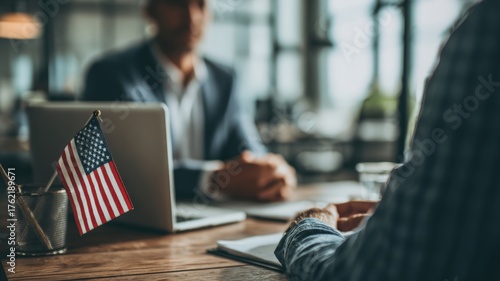Lawyer Advising Client on Immigration in Modern Office with U.S. Flag and Laptop