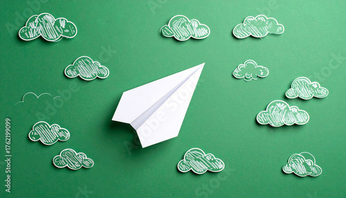 Avión de papel blanco sobre fondo verde con nubes blancas concepto de viaje, imaginación creatividad. para campañas de comunicación, viajes educación nuevas metas. o emprendimiento creativo