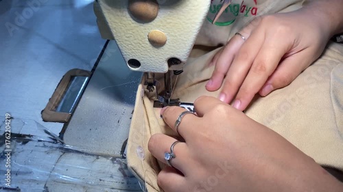 Expert tailor meticulously sewing seams on custom clothing with vintage machine, creating high end fashion apparel in home workshop studio