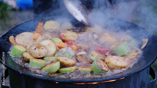vegetables fried in a cauldron over a fire, close-up
