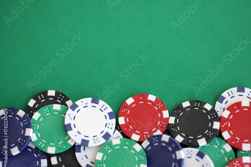 Casino gaming background with stacks of betting chips of different colors on green gaming mat