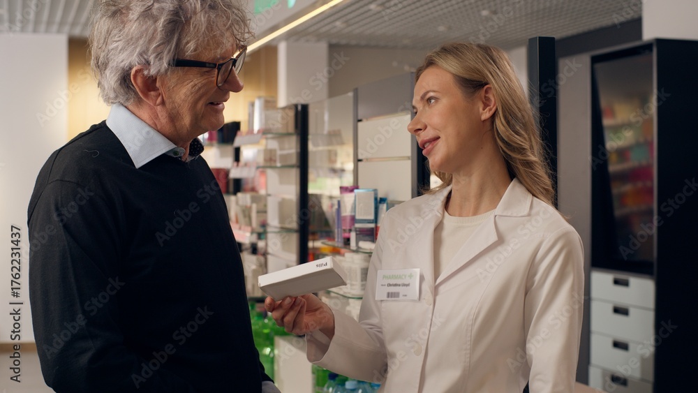 Obraz premium Doctor pharmacist advice medication prescription pills vitamins drugs in pharmacy woman help old man assisting customer medical consultation health care service medicine recommendation in drugstore