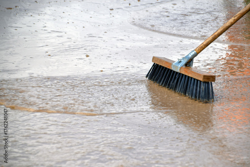 scrubbing the floor with a brush to remove the mud after flooding