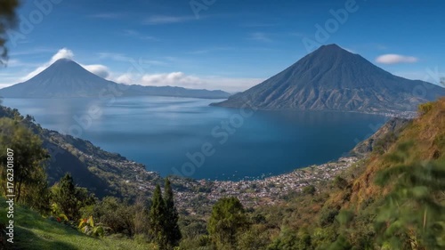 Lake view with mountains, towns, and verdant hillsides under a partly cloudy sky