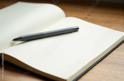 Wallpaper Mural Open blank notebook with a silver pen resting on the pages on a wooden surface Torontodigital.ca