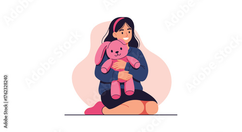 Young girl embraces pink bunny toy happy and content.