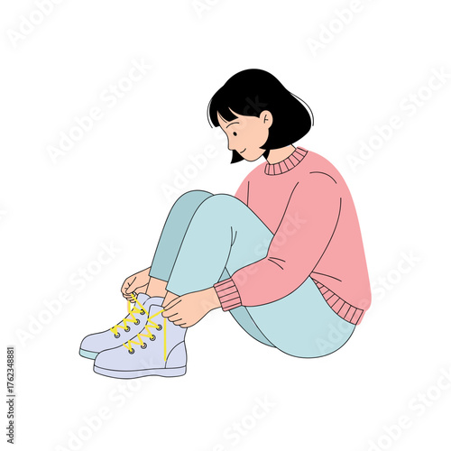 Young woman fastening winter boots while sitting on the floor  