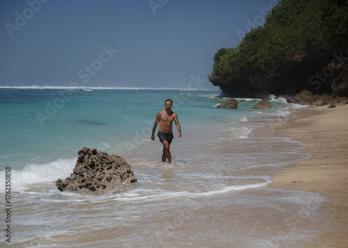 sporty man walking on a beach
