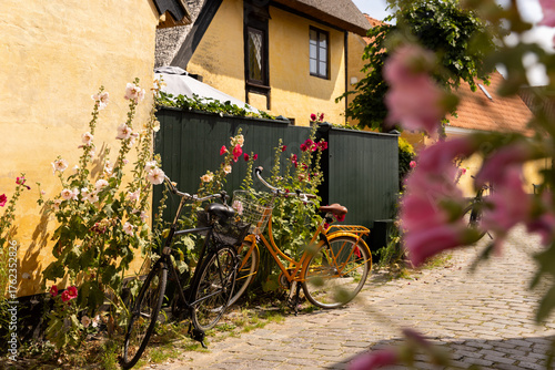 yellow A frame homes and small streets in dragor village copenhagen with bicycles in front, bike culture, 