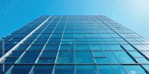 Modern Office Architecture An ultra wide shot of a modern office building facade, showcasing geometric patterns and reflective glass. The sky is clear blue. No people or any implied human presence.