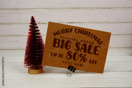 Festive display with small decorative Christmas trees with "Special Offer Merry Christmas Big Sale up to 80% off, Promotion Holiday Sale Event