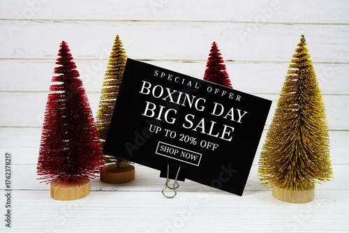 Festive display with small decorative Christmas trees with "Special Offer Boxing Day Big Sale up to 20% off, Promotion Holiday Sale Event