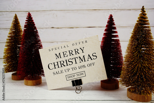 Festive display with small decorative Christmas trees with "Special Offer Merry Christmas Big Sale up to 40% off, Promotion Holiday Sale Event