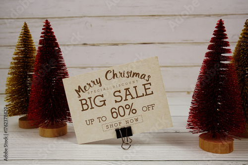Festive display with small decorative Christmas trees with "Special Offer Merry Christmas Big Sale up to 60% off, Promotion Holiday Sale Event