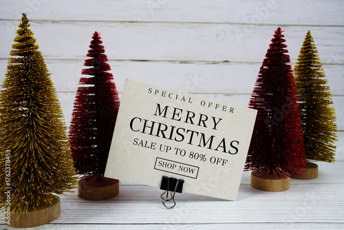 Festive display with small decorative Christmas trees with "Special Offer Merry Christmas Big Sale up to 80% off, Promotion Holiday Sale Event