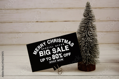 Festive display with small decorative Christmas trees with "Special Offer Merry Christmas Big Sale up to 80% off, Promotion Holiday Sale Event