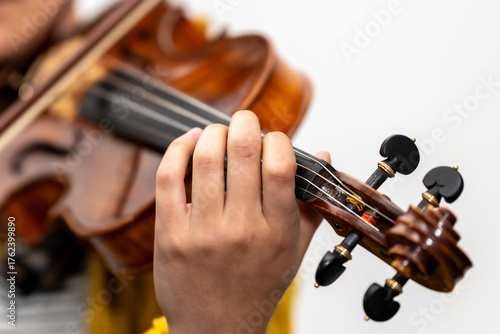 Musician's hand pressing violin strings playing classical music