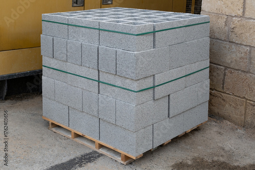 Constructions material, stack of textured  concrete blocks  ready for transport and use in large-scale construction.