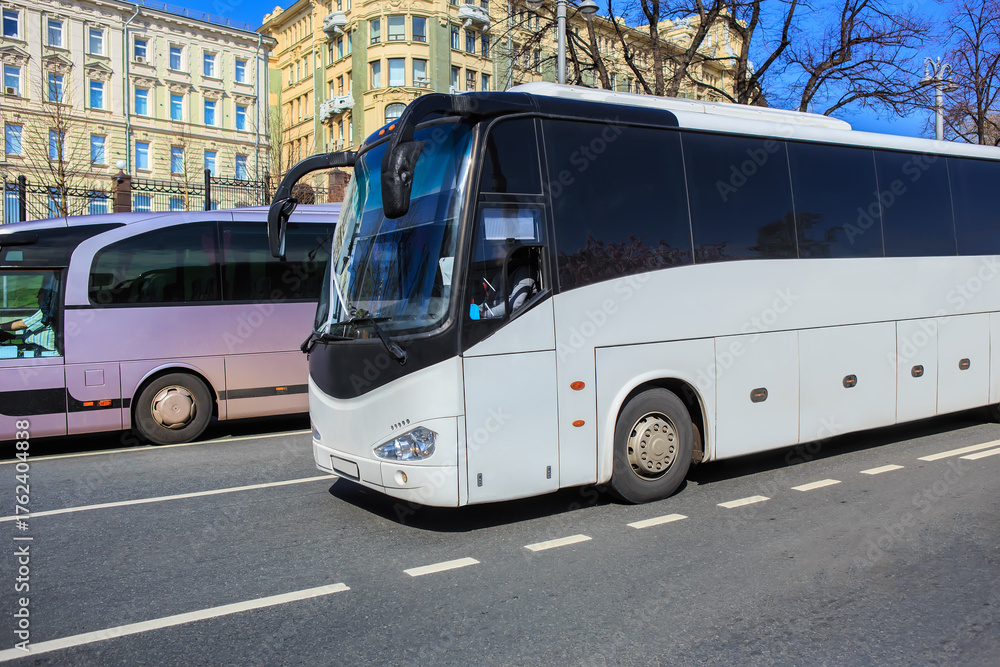 Fototapeta premium Tourist buses move along a city street