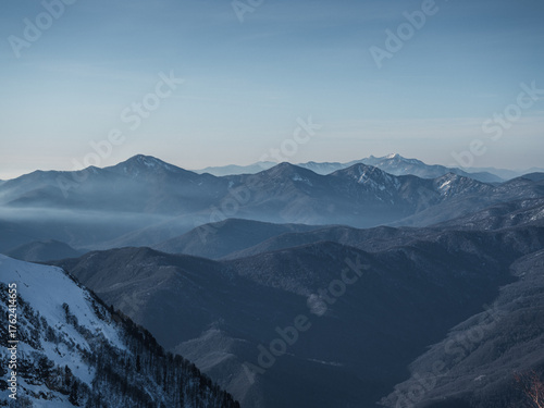 Winter mountain landscape, snowy peaks with evening fog