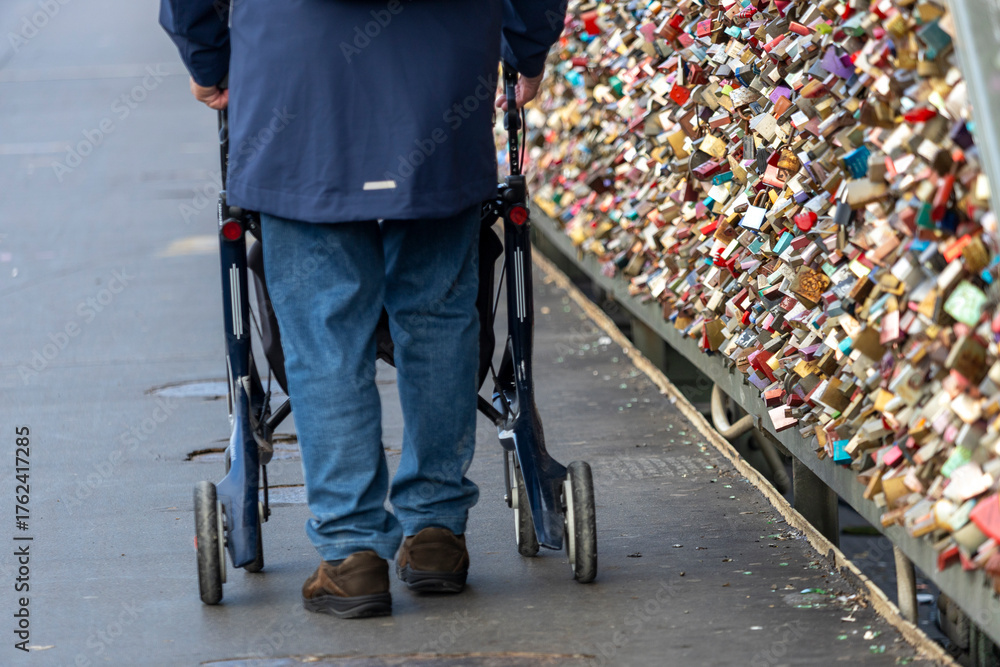 Obraz premium a man with rollators walk across the Hohenzollern Bridge, Cologne