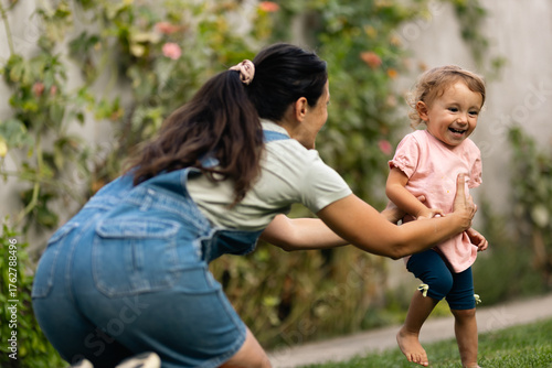 Joyful Caretaker Playing Outdoors with Happy Child in Sunny Garden