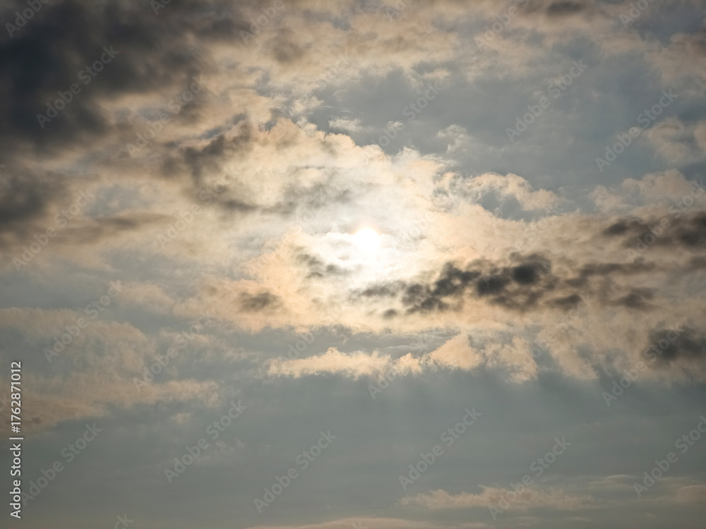 Fototapeta premium Sunlight shining through layered gray clouds