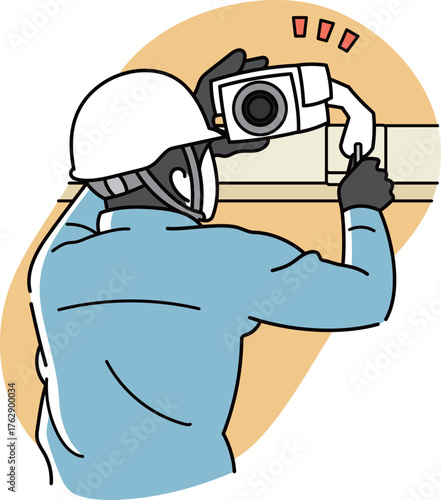 防犯カメラの取付、画角調整をしている男性作業員