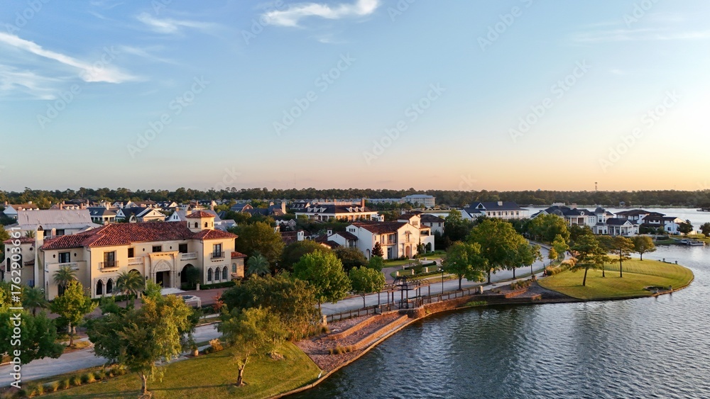 Obraz premium Aerial view of a town with luxurious houses next to Woodlands lake in Houston, United States by sunset time