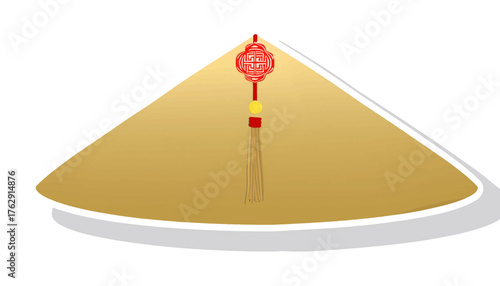 A golden Asian conical hat decorated with a red Lunar New Year tassel ornament.