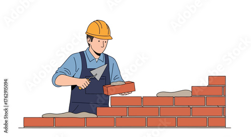 A construction worker builds a brick wall wearing a hard hat and holding a trowel