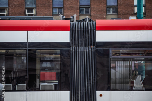 Close detail of a Toronto streetcar shows the articulated bellows, with windows at platform height, on public transit design and urban transportation. toronto tram is a transit system in Canada.