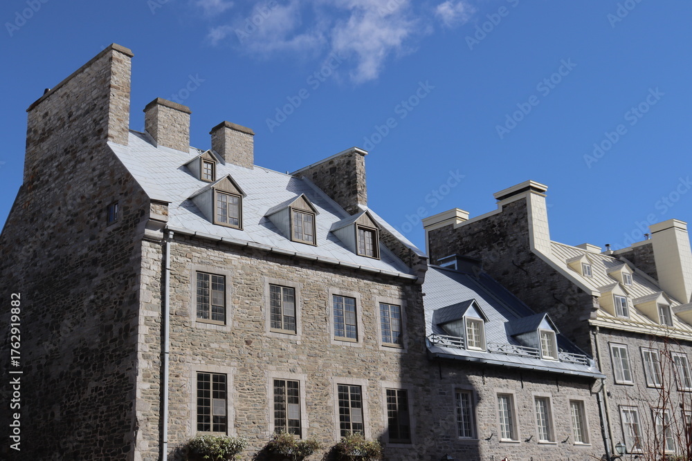 Fototapeta premium A view in summer of the Old Quebec in Canada with ancient architecture. Ancient building with stone facade and old building renovated . Historic building in Royale Place in Quebec city in Canada.