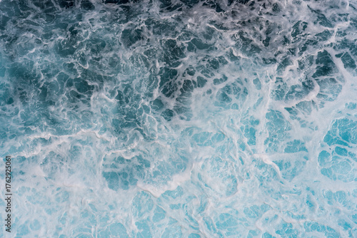 Fototapeta Naklejka Na Ścianę i Meble -  Texture of marine splashes with crashing ocean wave foam showing clear dark blue water surface and deep sea natural background