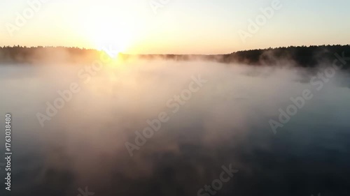 Wallpaper Mural A wide, atmospheric drone shot over a calm lake covered in thick, rolling fog during a serene sunrise, with a shallow depth of field mist, calm, tranquility Torontodigital.ca