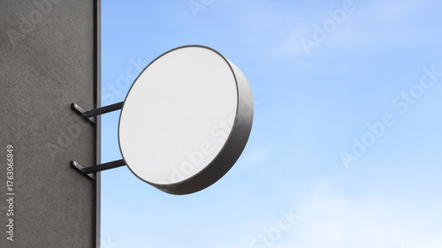 壁に取り付けられた空白の白い屋外用丸型看板　モックアップ