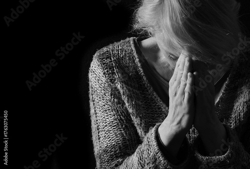 woman praying with hands together on grey black background with people stock image stock photo