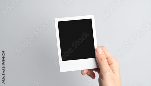 Hand Holding Blank Instant Photo Print Frame on Neutral Background